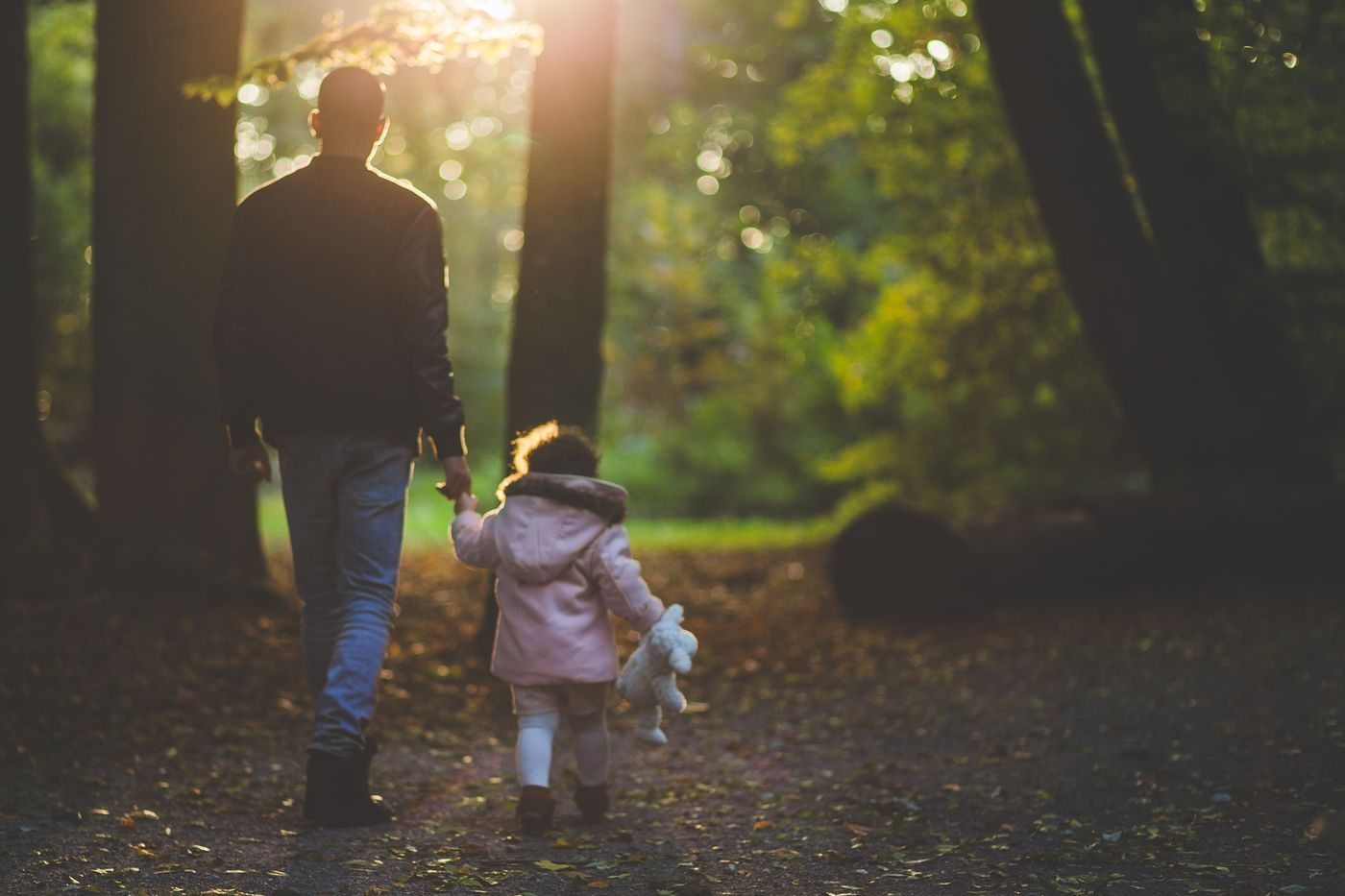 Un padre pasea con su hija por el parque